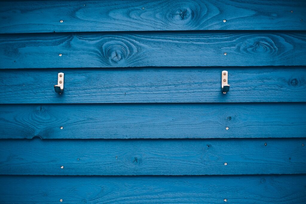 grey metal hook on blue wood plank